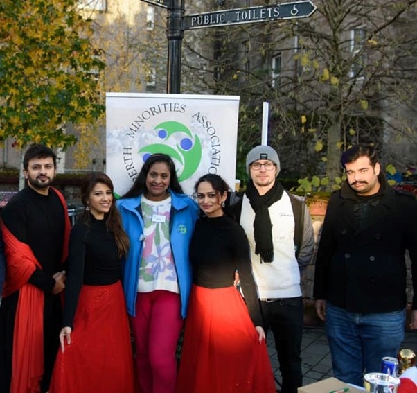 Six young volunteers of different ethnicities in front of a banner