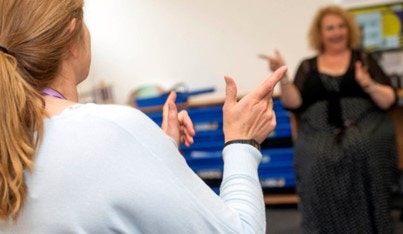 Two women practising sign language together