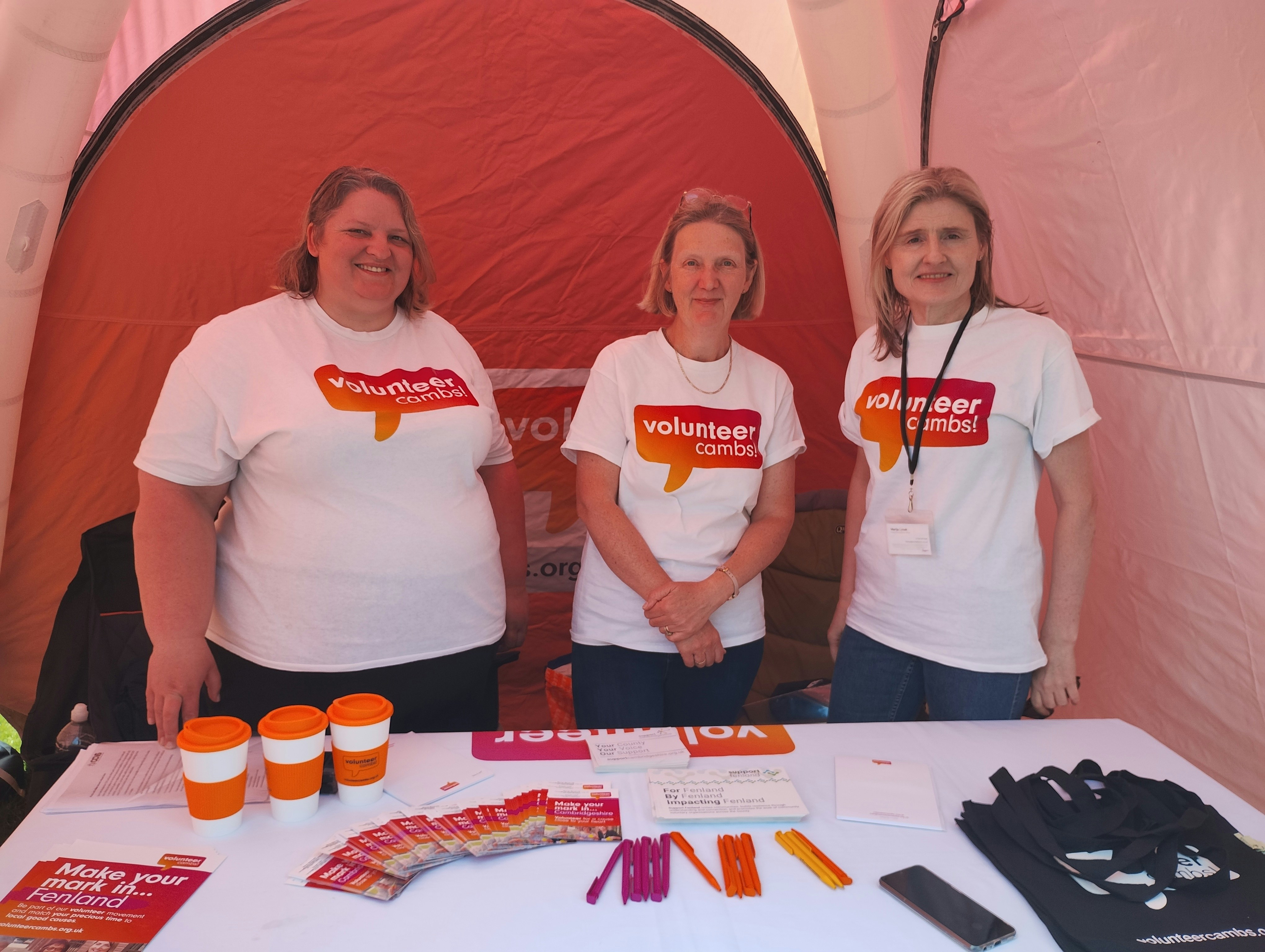 Two people wearing Volunteer Cambs t shirts