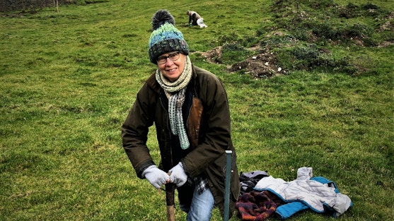 Photo of Alison planting a tree