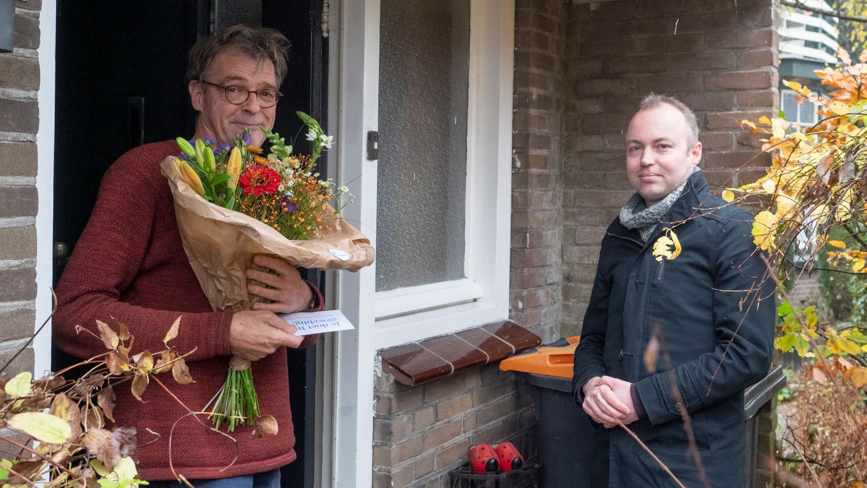 wethouder Rob de Geest deelt bloemen uit