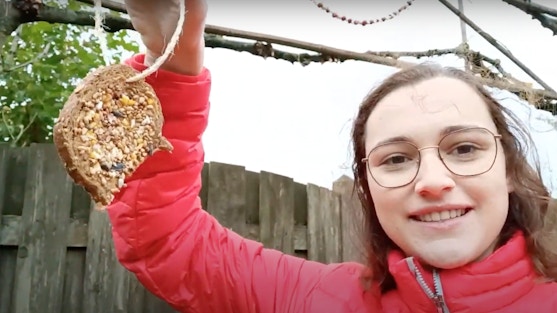 Meisje laat zelf gemaakte wintervogelvoer zien, gemaakt van een boterham met pindakaas
